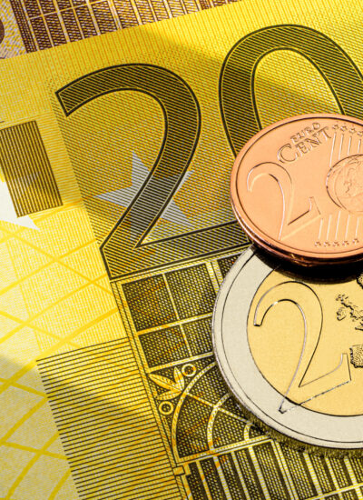 Different euro coins, one euro and one cent on the top of 200 yellow euro banknote.